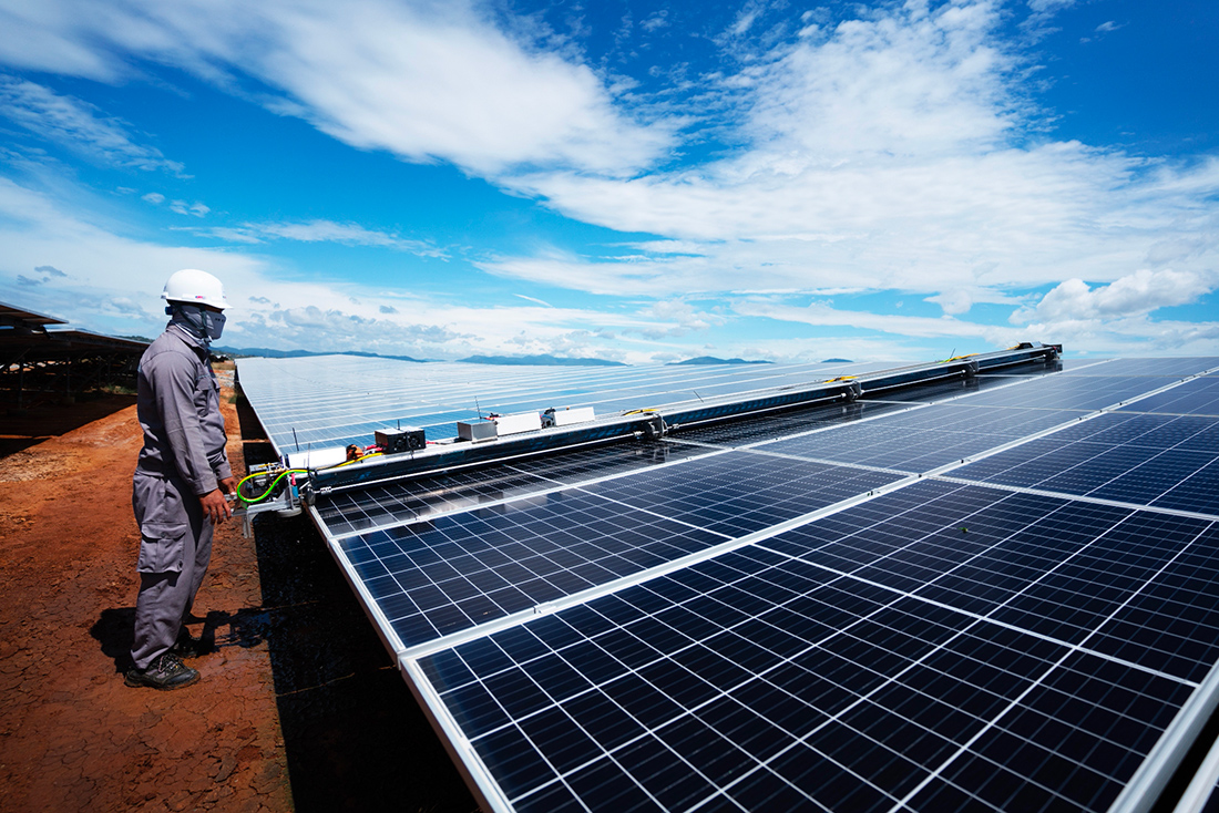Technician operating robotic solar panel cleaner