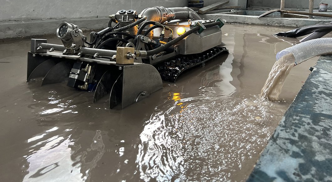 Dredging robot removing sludge in an industrial basin