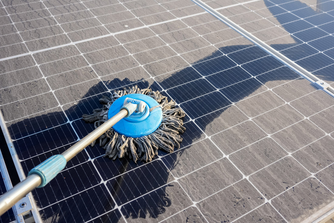 Dust build-up on a solar panel being cleaned