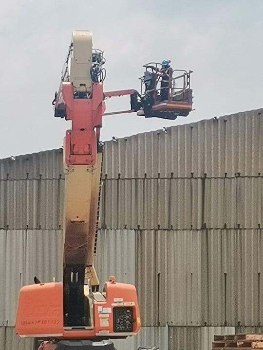 Boom lift positioned for safe at-height asbestos sheet removal