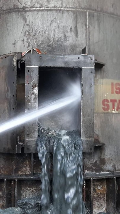 High-pressure water jet stripping fouling from a vessel manway