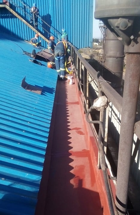 Crew clearing and recoating an industrial box gutter at height