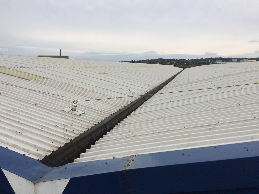 Long-run factory roof valley gutter cleared and flowing freely