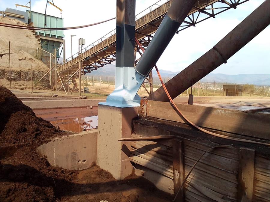 Coated column baseplate next to conveyor and settling pond