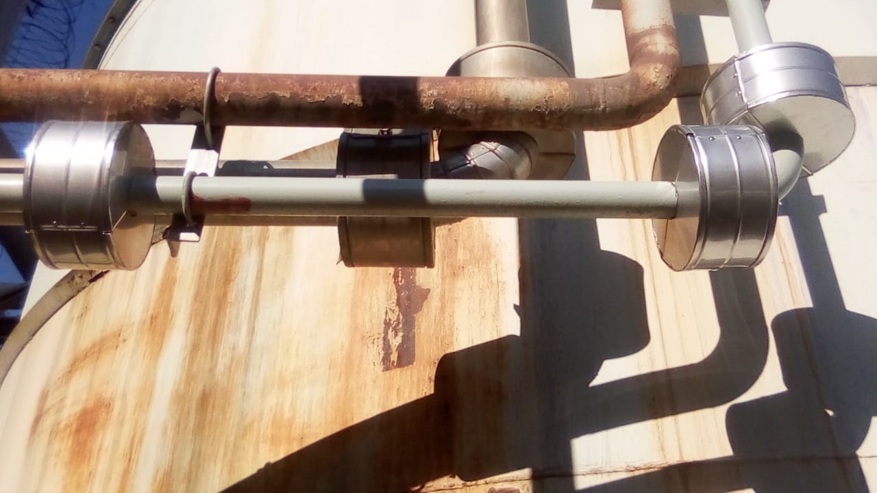 End caps and cladding on insulated pipework against storage tank