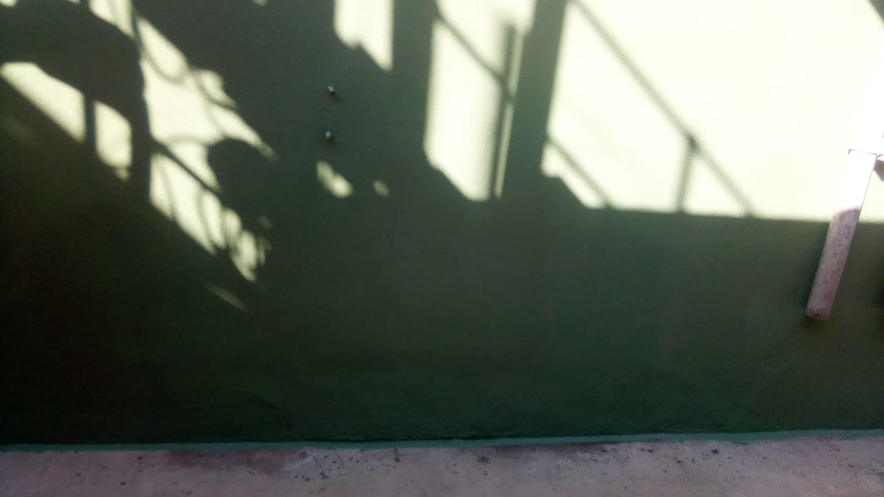 Cured chemical-resistant coating on containment wall