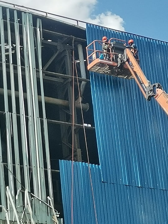 MEWP-supported sheeting installation on industrial building cladding