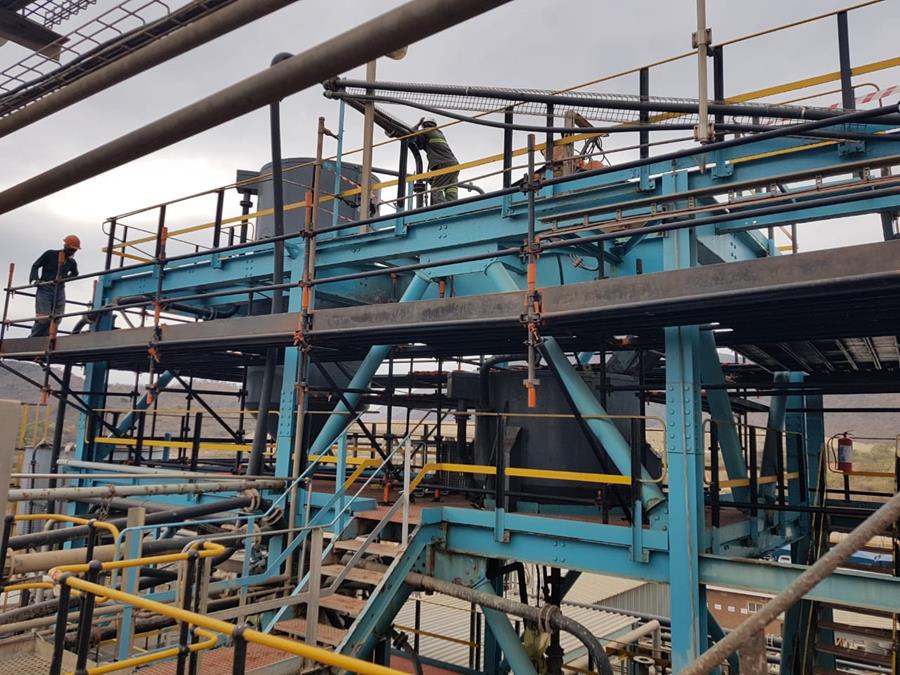 Refurbished blue plant structures with crew working at height