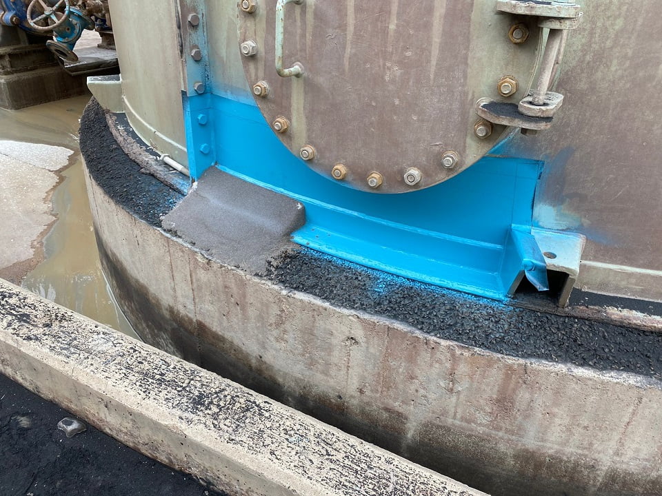 Tank base flange protected with chemical-resistant coating