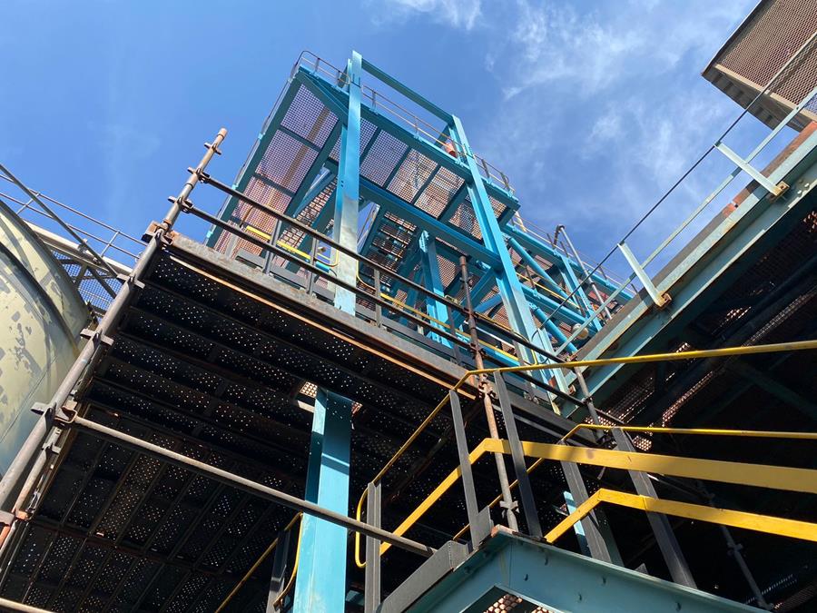 Recoated teal structural framework and access stairs at processing plant