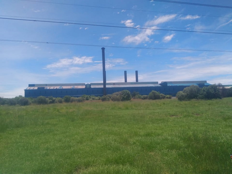 Distant view of large industrial plant with refurbished blue side sheeting