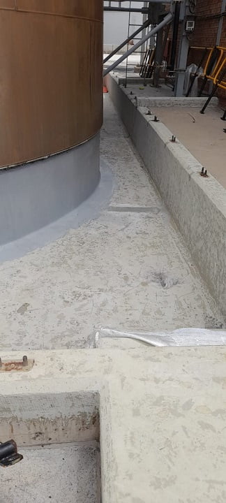 Cured bund floor lining around tank perimeter