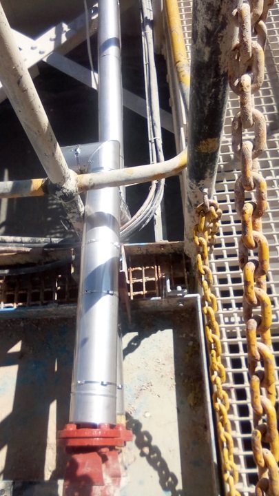 Vertical insulated pipework with metal cladding next to access platform
