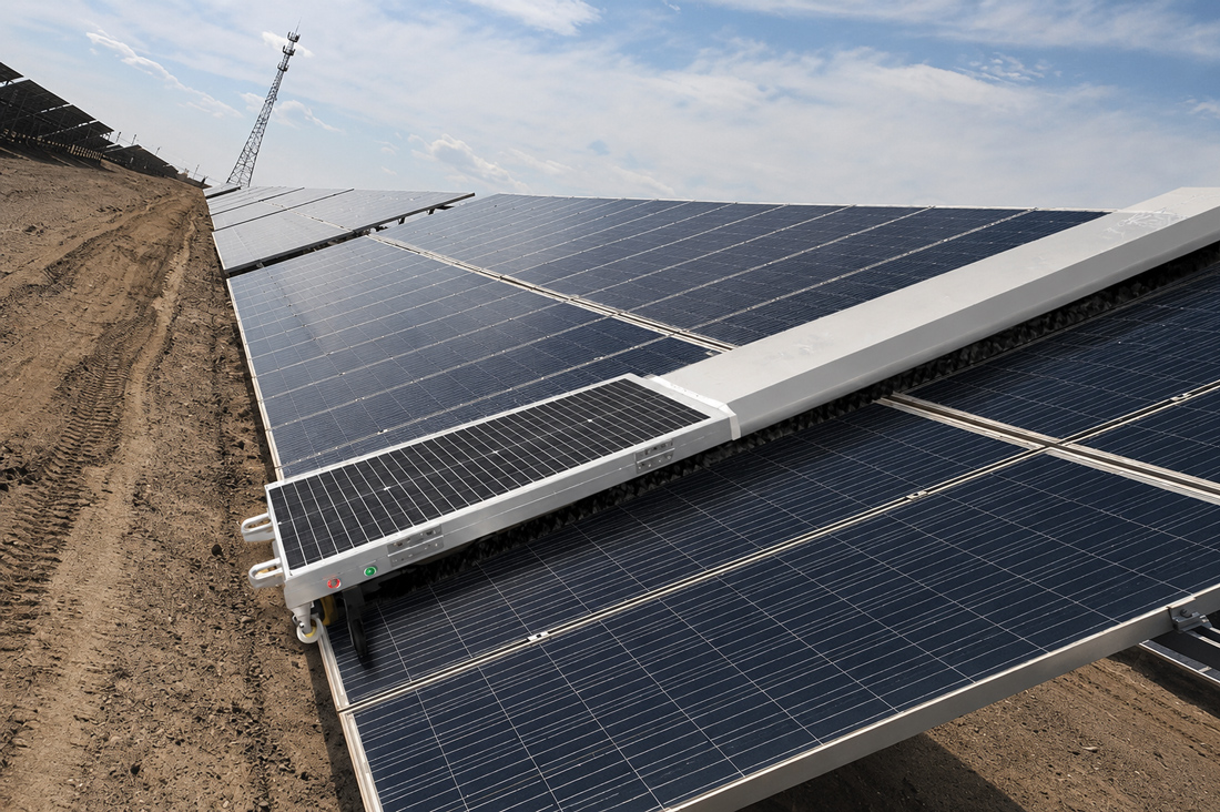 Robotic solar panel cleaner working across a utility-scale array